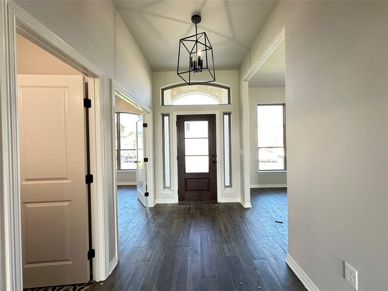 Entrance foyer with dark wood-style floors and a chandelier Entrance foyer with dark wood-style floors and a chandelier