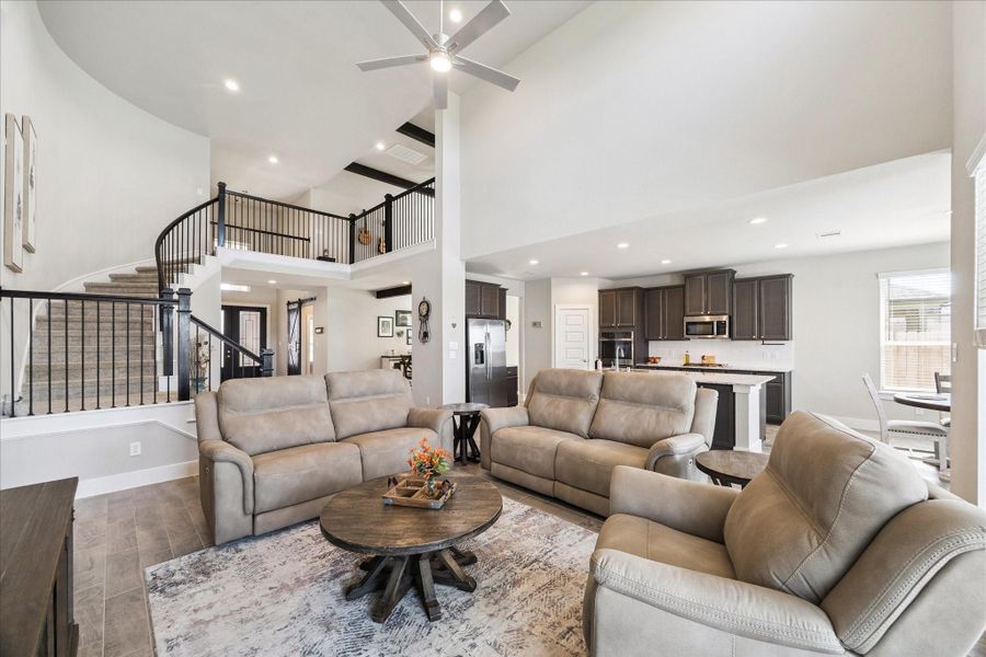 Open-concept living room with high ceilings, abundant natural light, and direct flow into the kitchen. Open-concept living room with high ceilings, abundant natural light, and direct flow into the kitchen.