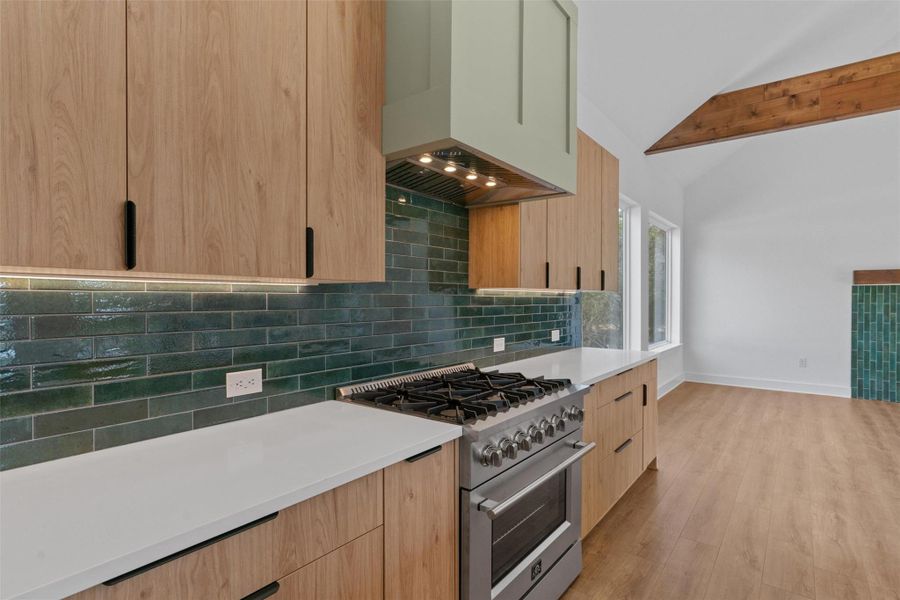 Culinary excellence awaits in this well-appointed kitchen, showcasing a sleek gas range, contemporary cabinetry, and a striking tile backsplash. Culinary excellence awaits in this well-appointed kitchen, showcasing a sleek gas range, contemporary cabinetry, and a striking tile backsplash.