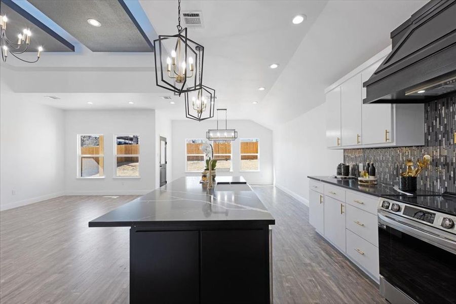 Kitchen with a center island, dark countertops, open floor plan, and white cabinets