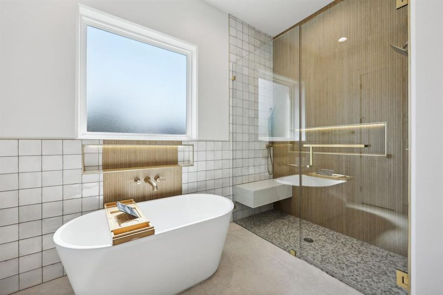 Bathroom with separate shower and tub, tile patterned flooring, and tile walls