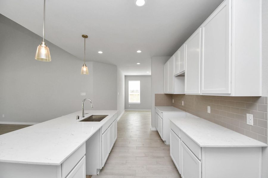 Discover another perspective of this stunning kitchen, generously appointed with an abundance of counter space. Sample photo of completed home with similar floor plan. Actual colors and selections may vary. Discover another perspective of this stunning kitchen, generously appointed with an abundance of counter space. Sample photo of completed home with similar floor plan. Actual colors and selections may vary.