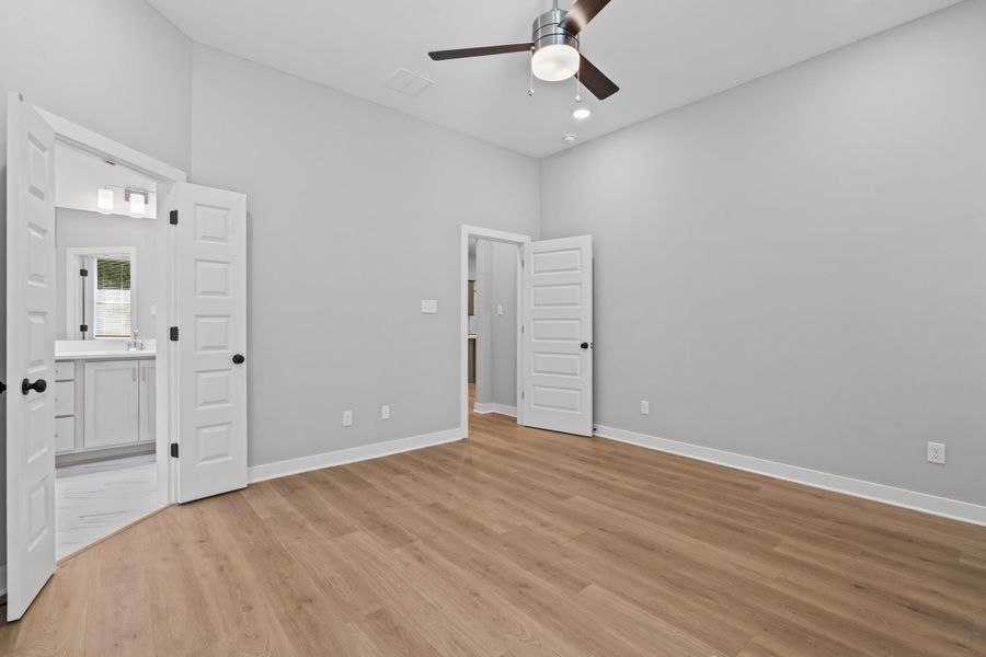 Unfurnished bedroom featuring a ceiling fan, light wood-type flooring, recessed lighting, and ensuite bathroom