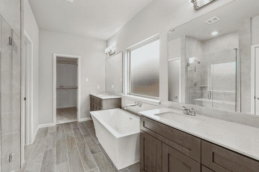 Indulge in a tranquil primary bathroom, boasting a spacious soaking tub and dual vanities.
