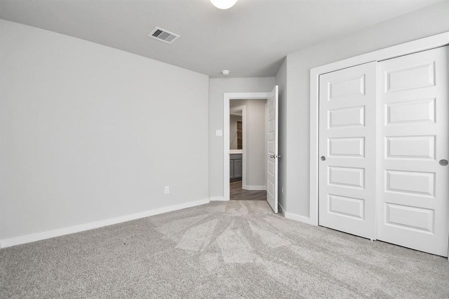 Spacious secondary bedrooms with large windows, neutral paint, and plush carpet. Sample photo of completed home. Actual color and selections may vary.