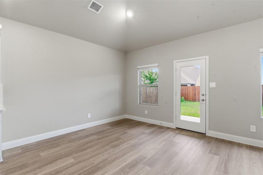 The property features light-colored walls, light wood-style flooring, and an exterior door with a glass panel providing access to a fenced outdoor area