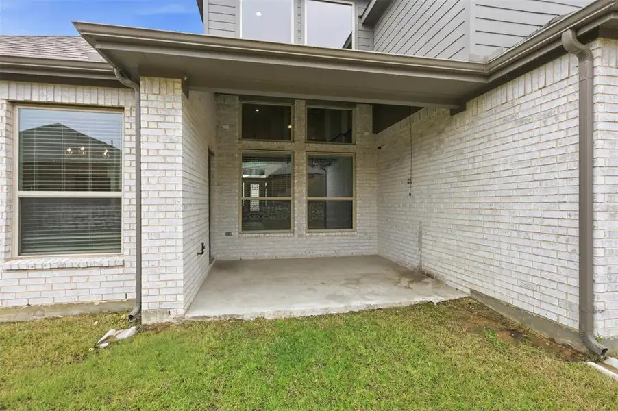 Covered back patio offering a shaded outdoor space for relaxing, entertaining, or enjoying the backyard.