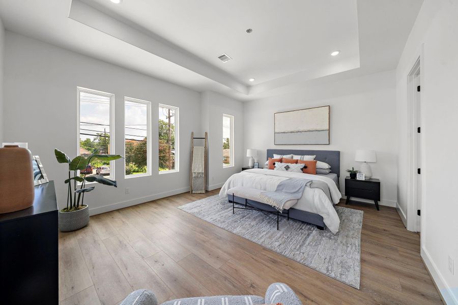 This spacious bedroom features large windows for natural light, a stylish tray ceiling, and LVP floors. This spacious bedroom features large windows for natural light, a stylish tray ceiling, and LVP floors.