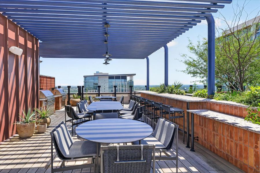 Rooftop deck with multiple seating areas and outdoor cooking stations, perfect for entertaining.