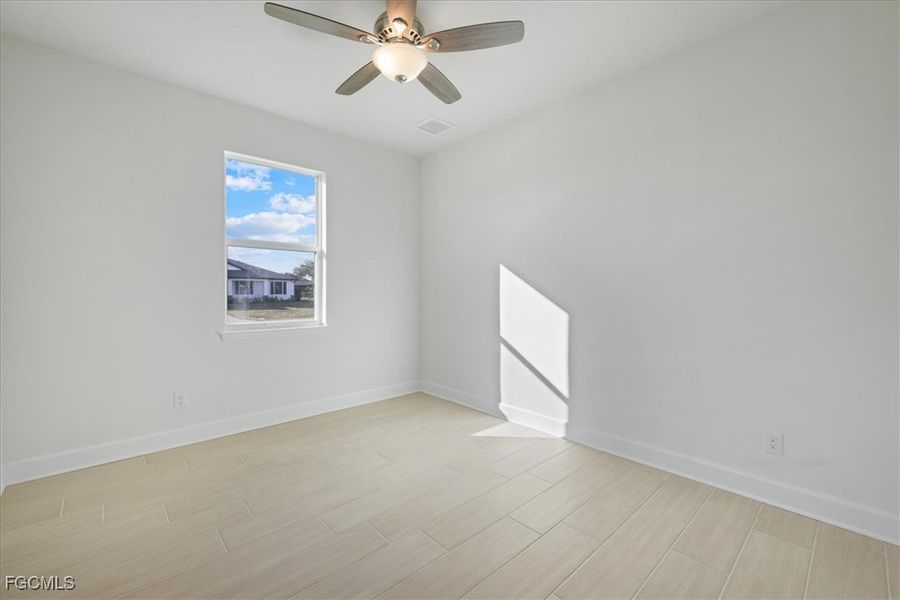 Spare room featuring wood finish floors and a ceiling fan Spare room featuring wood finish floors and a ceiling fan