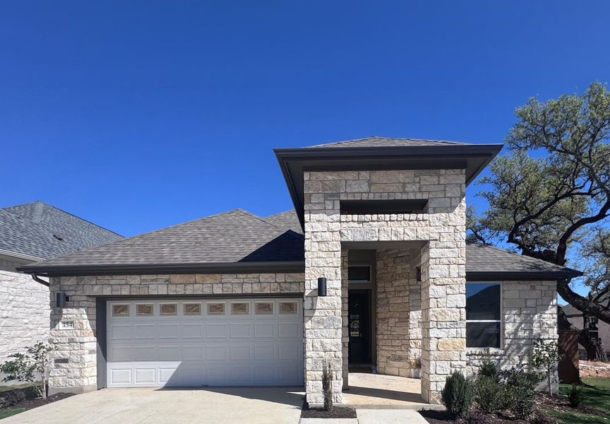 Front exterior of a new home in Persimmon, Buda, TX, highlighting curb appeal (Image 1). Front exterior of a new home in Persimmon, Buda, TX, highlighting curb appeal (Image 1).