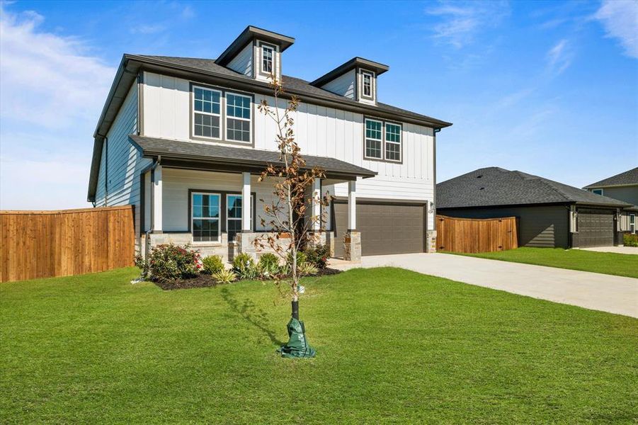 View of front of property with a front lawn and a garage View of front of property with a front lawn and a garage