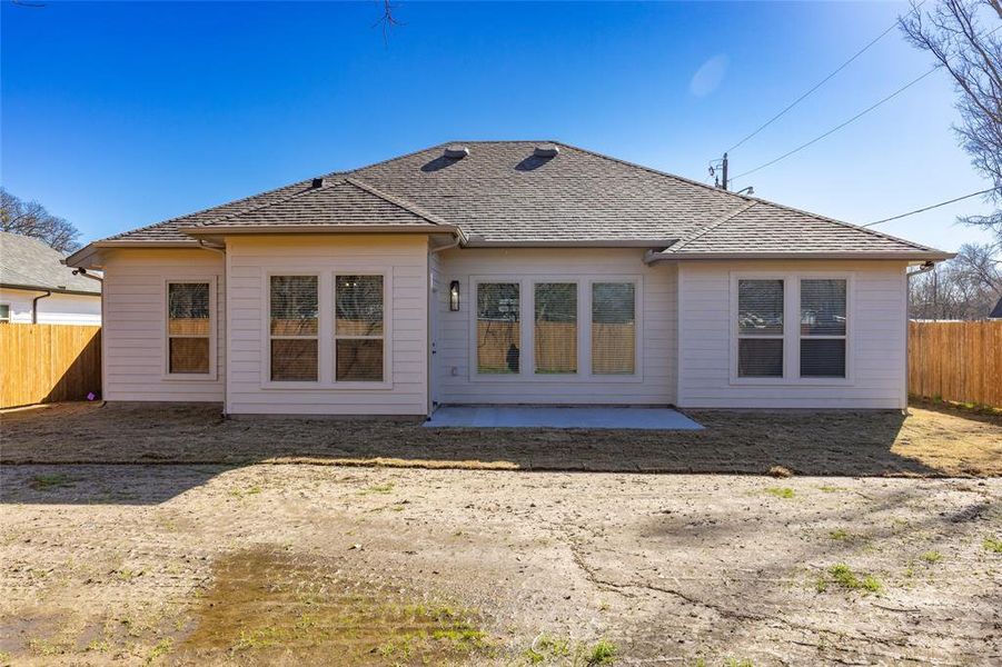 Rear view of property with a patio, fence, and a shingled roof