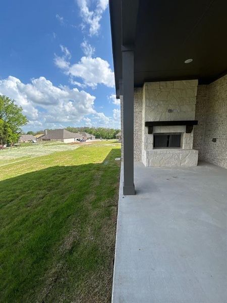 View of green lawn with a patio