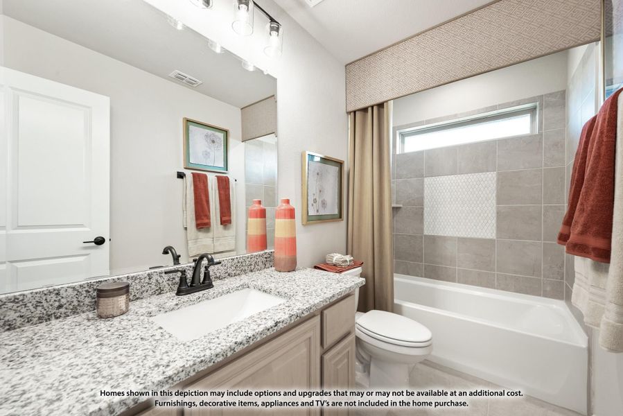 Bathroom with granite countertop vanity, tub-shower combo with gray tile surround, and white toilet