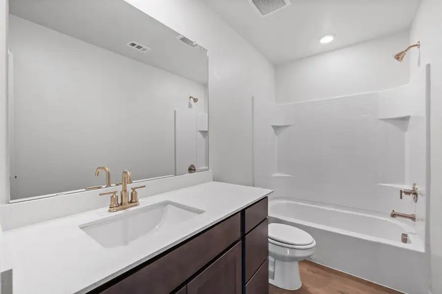 Full bathroom featuring shower / bathtub combination, toilet, wood finished floors, vanity,