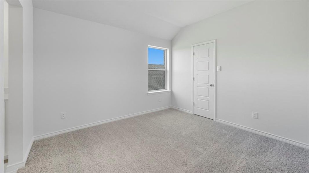 Unfurnished room featuring lofted ceiling and light carpet Unfurnished room featuring lofted ceiling and light carpet
