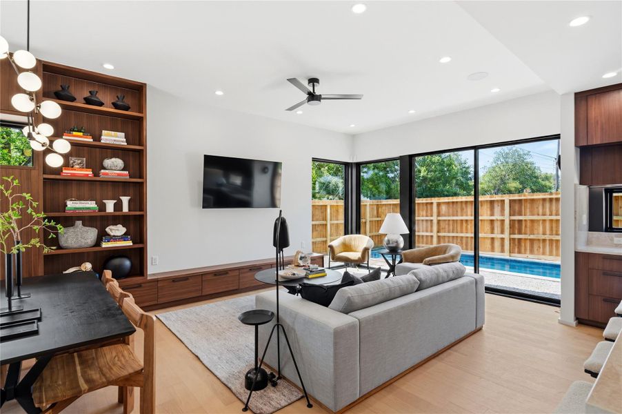Floor-to-ceiling glass doors provide seamless outdoor access to a private pool.