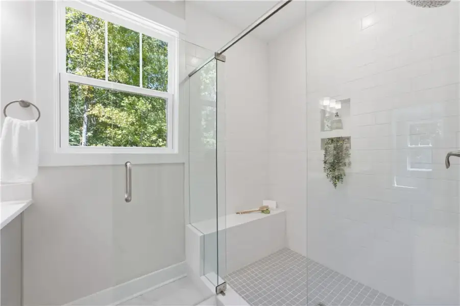Elegant tile details and a glass enclosure define