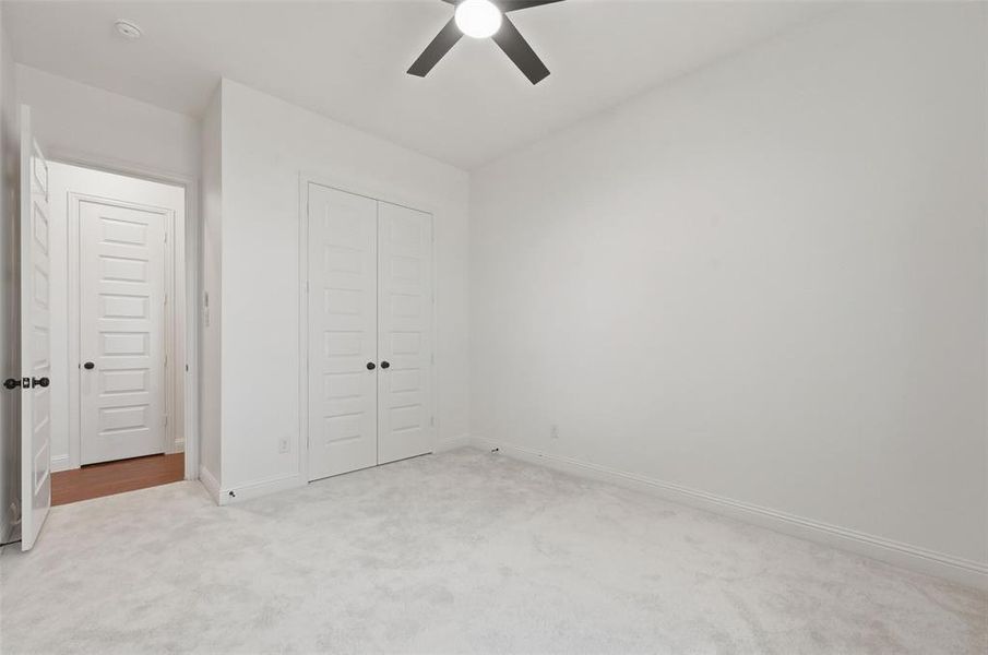Unfurnished bedroom with carpet, a closet, and ceiling fan