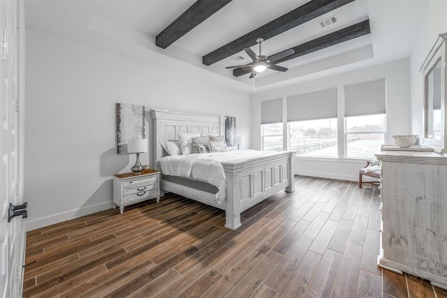 The Primary Bedroom is simply grand and overlooks the property.  The ceiling is highlighted with wood beams and is a wonderful retreat for the homeowner.