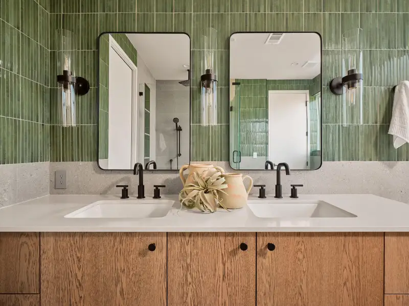 Bathroom featuring double vanity and tiled shower