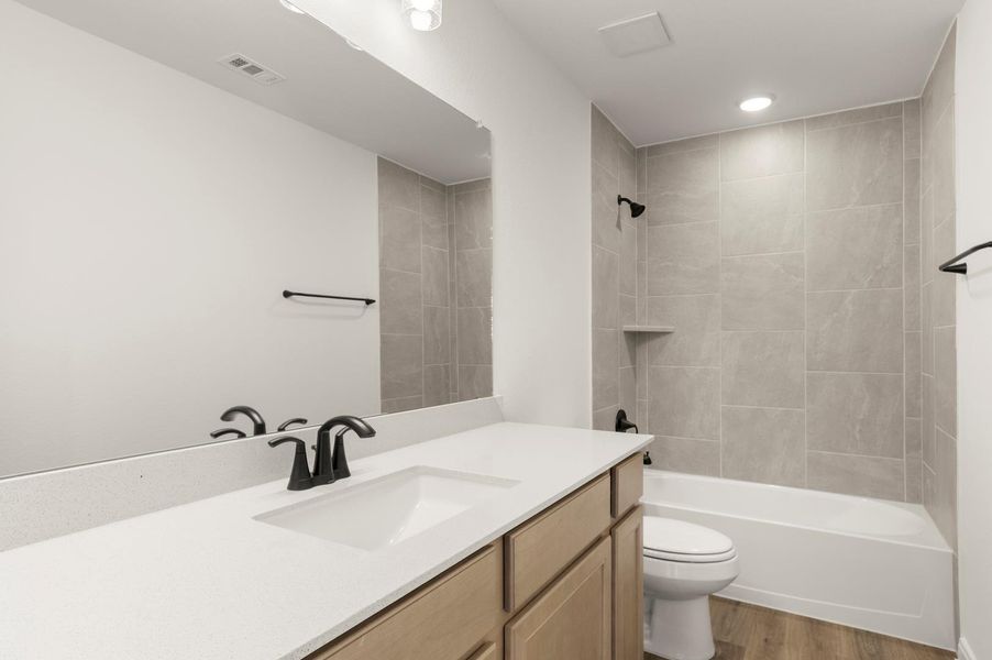 Bathroom featuring vanity, light wood-style flooring, tub / shower combination, and recessed lighting Bathroom featuring vanity, light wood-style flooring, tub / shower combination, and recessed lighting