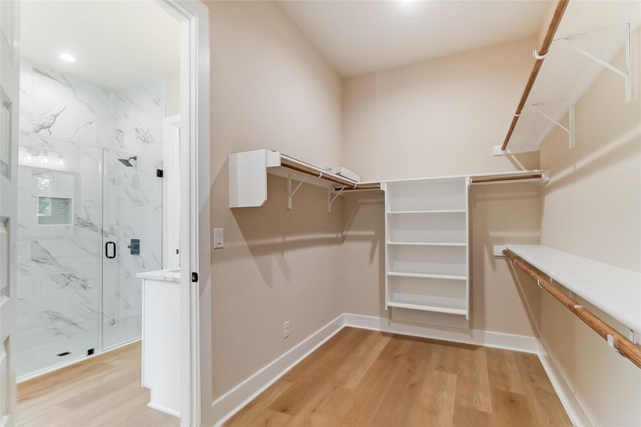 Walk in closet with light wood-style floors Walk in closet with light wood-style floors