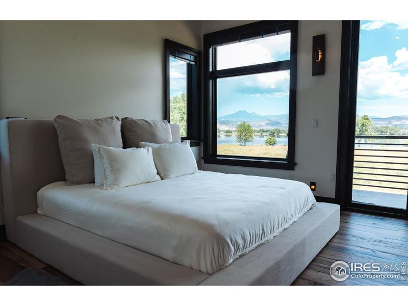 Primary bedroom with unobstructed views of field, lake and front range