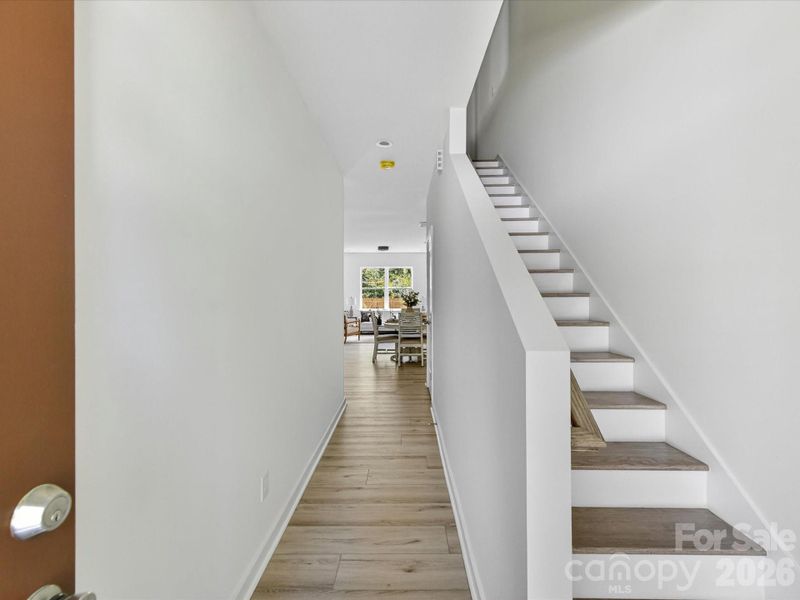 Bright and welcoming foyer featuring clean modern finishes, durable flooring, and a convenient staircase leading to the upper level. Bright and welcoming foyer featuring clean modern finishes, durable flooring, and a convenient staircase leading to the upper level.