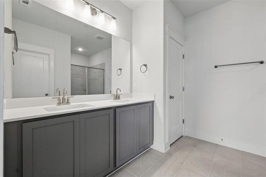 Bathroom featuring double vanity and a stall shower