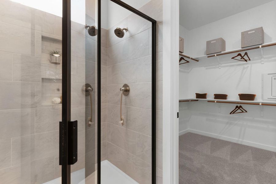 Full bath with a walk in closet and a shower stall