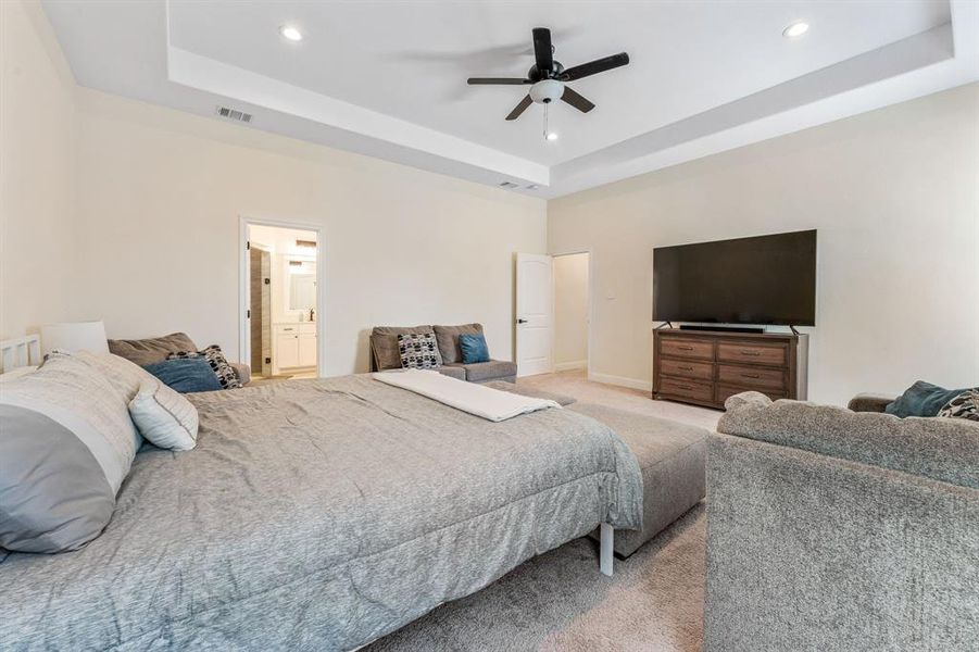 Bedroom featuring a tray ceiling, light carpet, ceiling fan, and recessed lighting Bedroom featuring a tray ceiling, light carpet, ceiling fan, and recessed lighting