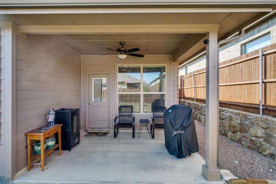 View of patio with a ceiling fan and fence