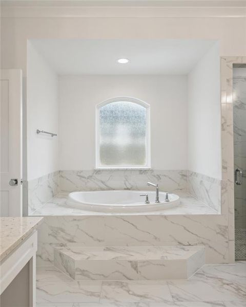 Bathroom featuring tile patterned flooring, shower with separate bathtub, and vanity