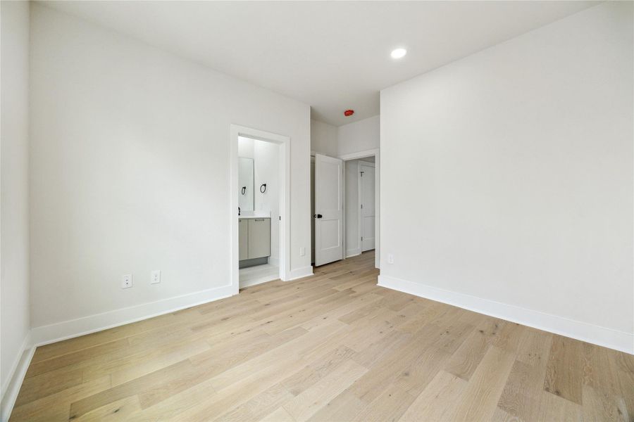 Spacious third-floor bedroom with elegant hardwood floors and an ensuite bathroom.