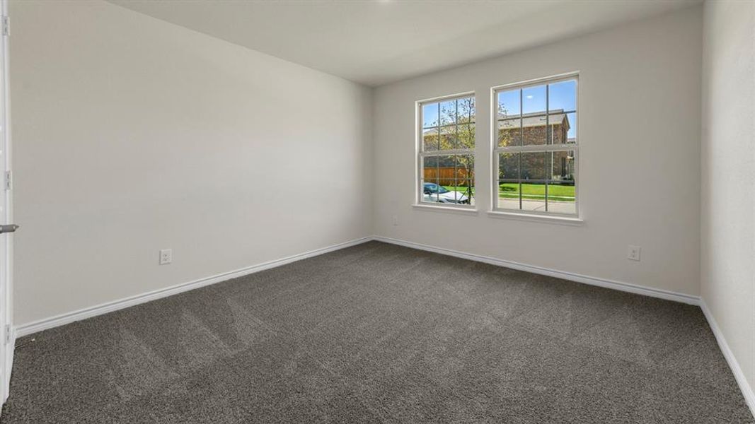 Room featuring grey carpeted floors and two windows providing natural light