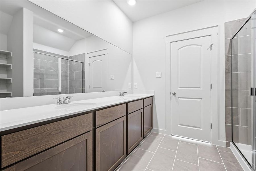 Full bath featuring double vanity, a shower stall, light tile patterned floors, and recessed lighting Full bath featuring double vanity, a shower stall, light tile patterned floors, and recessed lighting