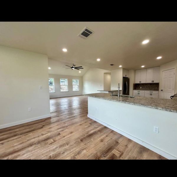 An open-concept living space with sleek flooring and a contemporary kitchen.