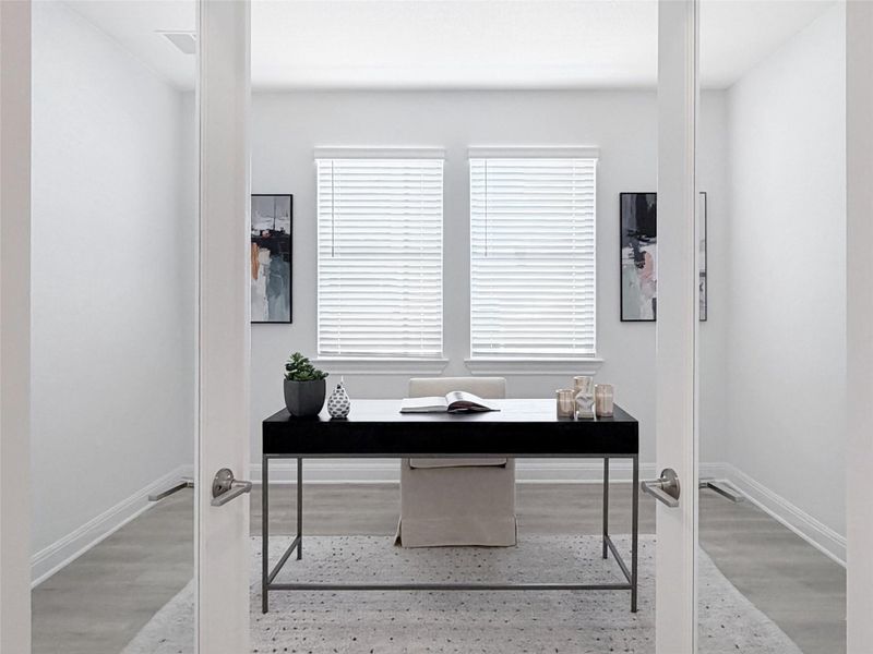 Office space with light wood-style floors and french doors