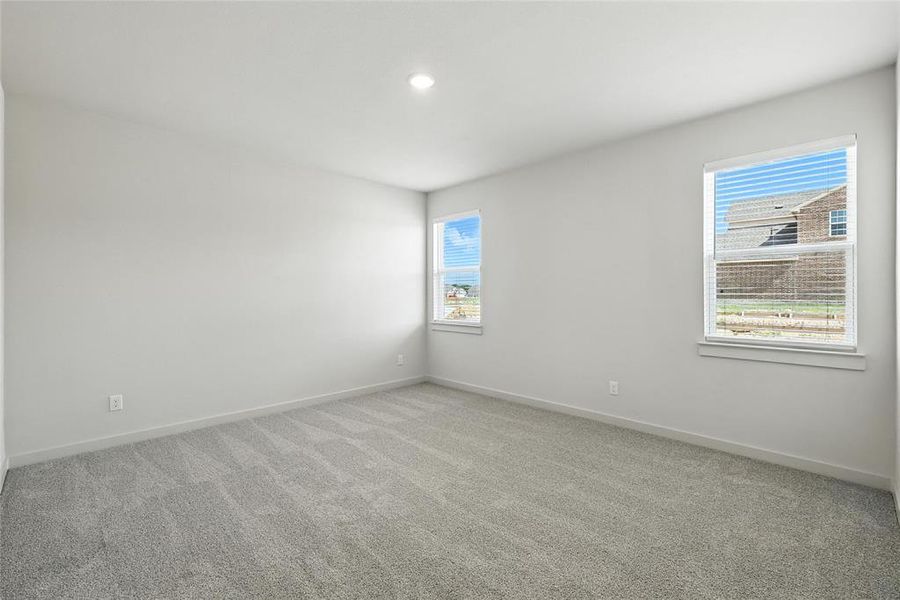Empty room with healthy amount of natural light, light carpet, and recessed lighting Empty room with healthy amount of natural light, light carpet, and recessed lighting