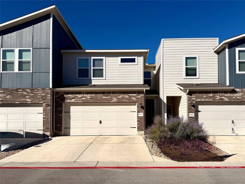 Modern home featuring brick siding, concrete driveway, and a garage Modern home featuring brick siding, concrete driveway, and a garage