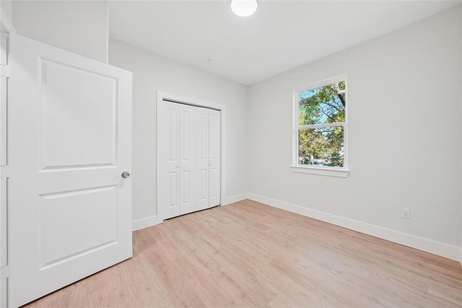 Unfurnished bedroom with light wood-style floors and a closet