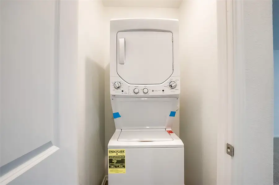 Laundry room with stacked washing machine and dryer