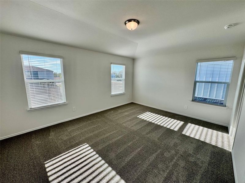 Carpeted spare room with lofted ceiling and baseboards