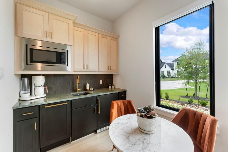Kitchenette includes custom cabinetry, upgraded countertops, dishwasher, mini fridge, and microwave.