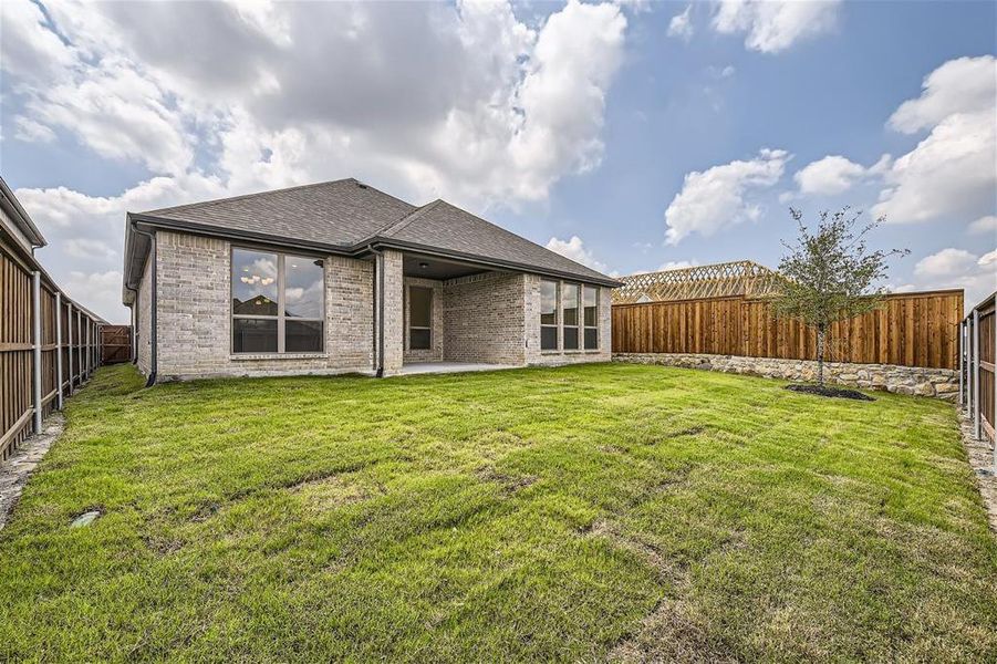 Rear view of property with a lawn