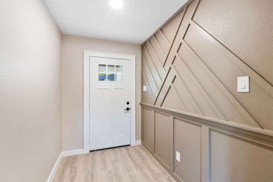 Doorway featuring wood finished floors and baseboards
