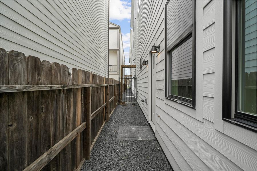 The graveled backyard has coach lighting,  a water spigot and direct access to the third bedroom.