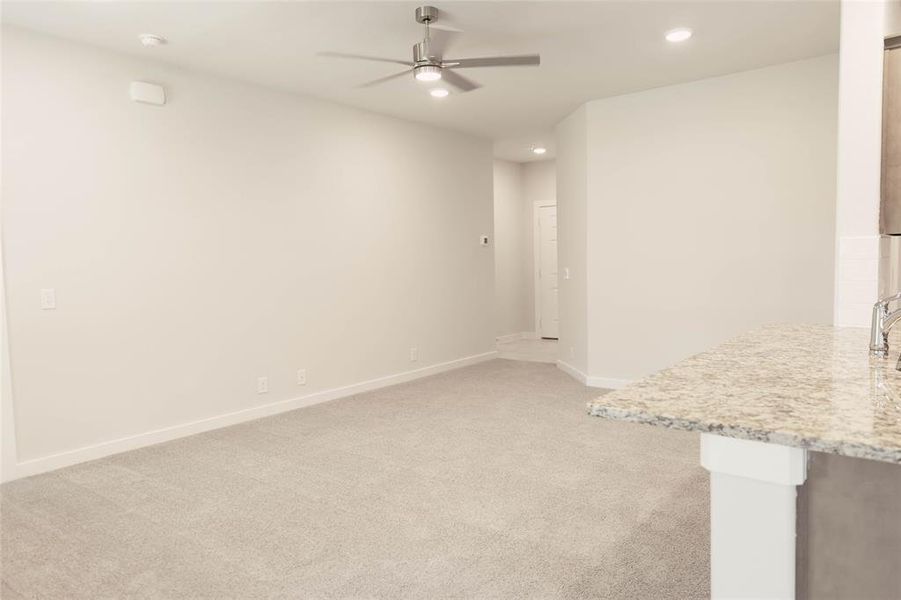 Unfurnished room featuring light colored carpet and ceiling fan